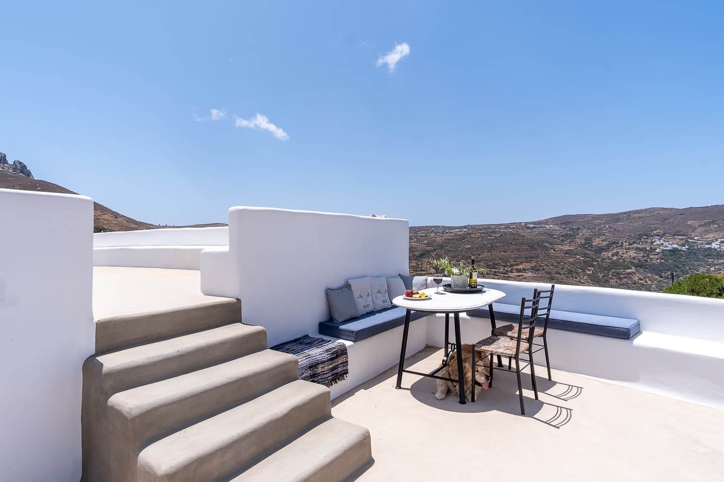 The terrace dining table at Casa di Lavalle set for two, overlooking the Tinos hillside and neighbouring village.