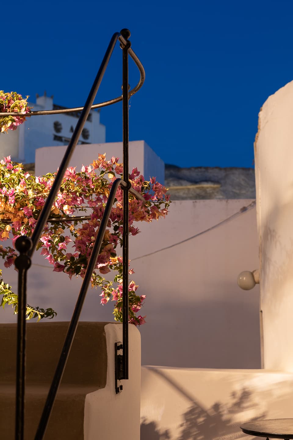 Bougainvillea lit at dusk on the terrace at Casa di Lavalle, whitewashed walls turning blue in the evening light.