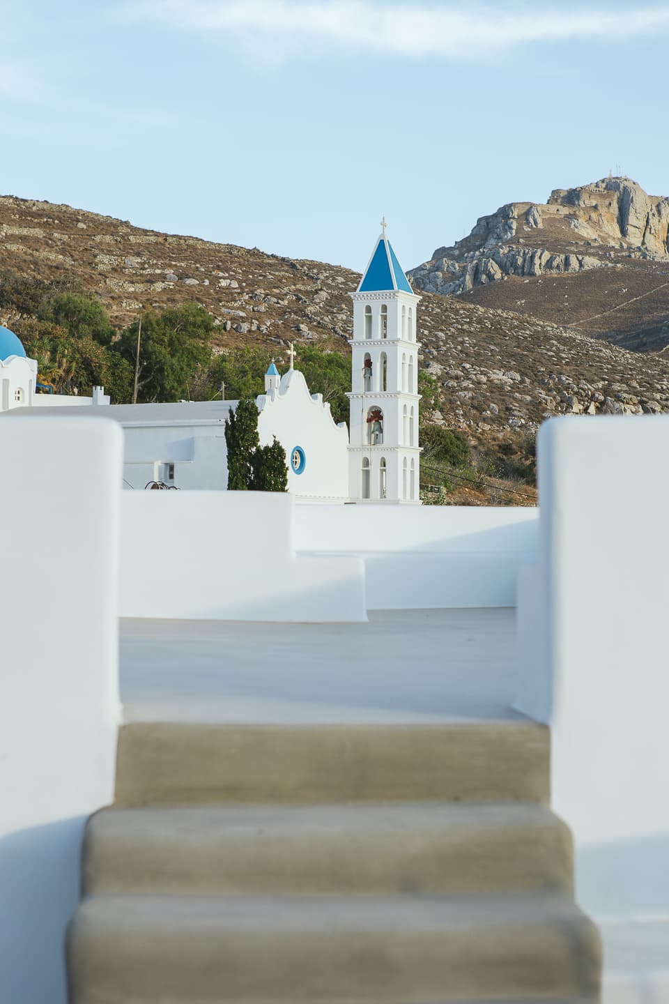 The view from the terrace steps at Casa di Lavalle across whitewashed rooftops and a village bell tower to Mount Exomvourgo.